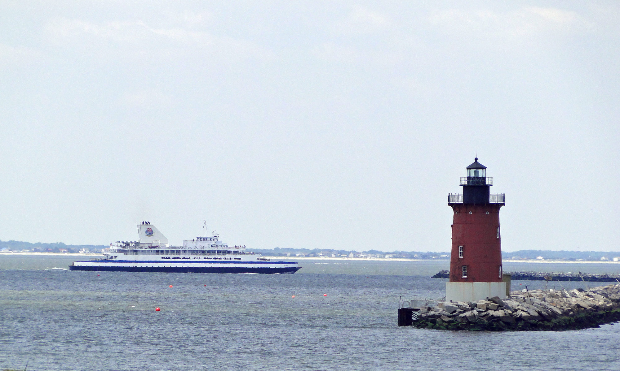 Ferry shuttle boat seen going by iconic red lighthouse near Lewes, DE